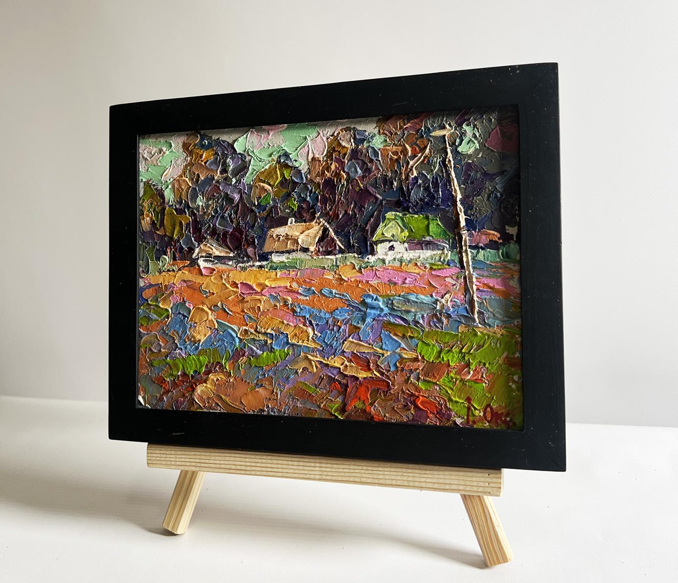 Vibrant oil painting of colorful fields and village by Oksana Ivanyuk in black frame