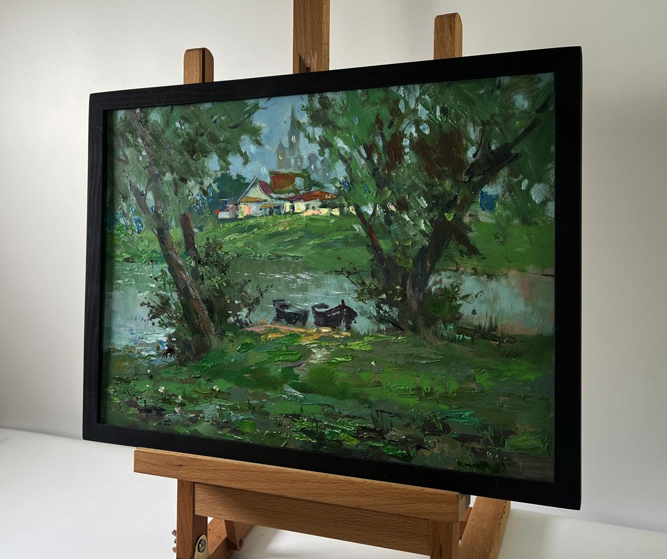 Framed impressionist oil painting of riverside village with boats by Yuriy Suprunchuk