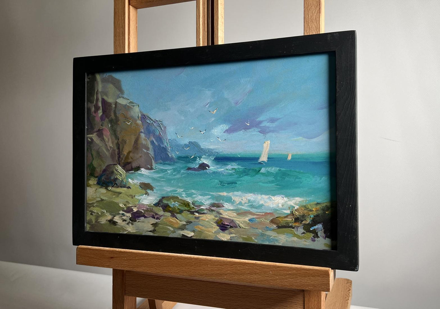 Framed oil painting by Yuriy Suprunchuk: seagulls over turquoise sea with cliffs and sailboats