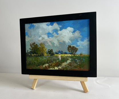 Oil painting by Yuriy Suprunchuk: girl walking in black-framed field landscape