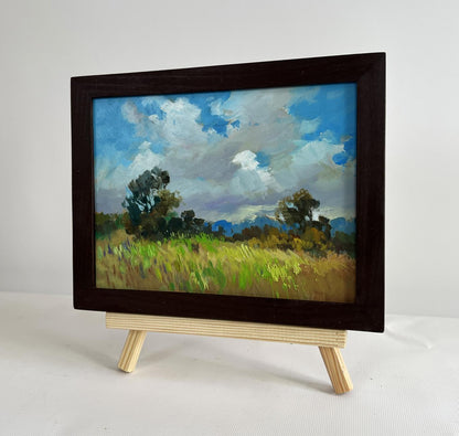 Oil painting of summer meadow glade by Yuriy Suprunchuk in wooden frame on easel