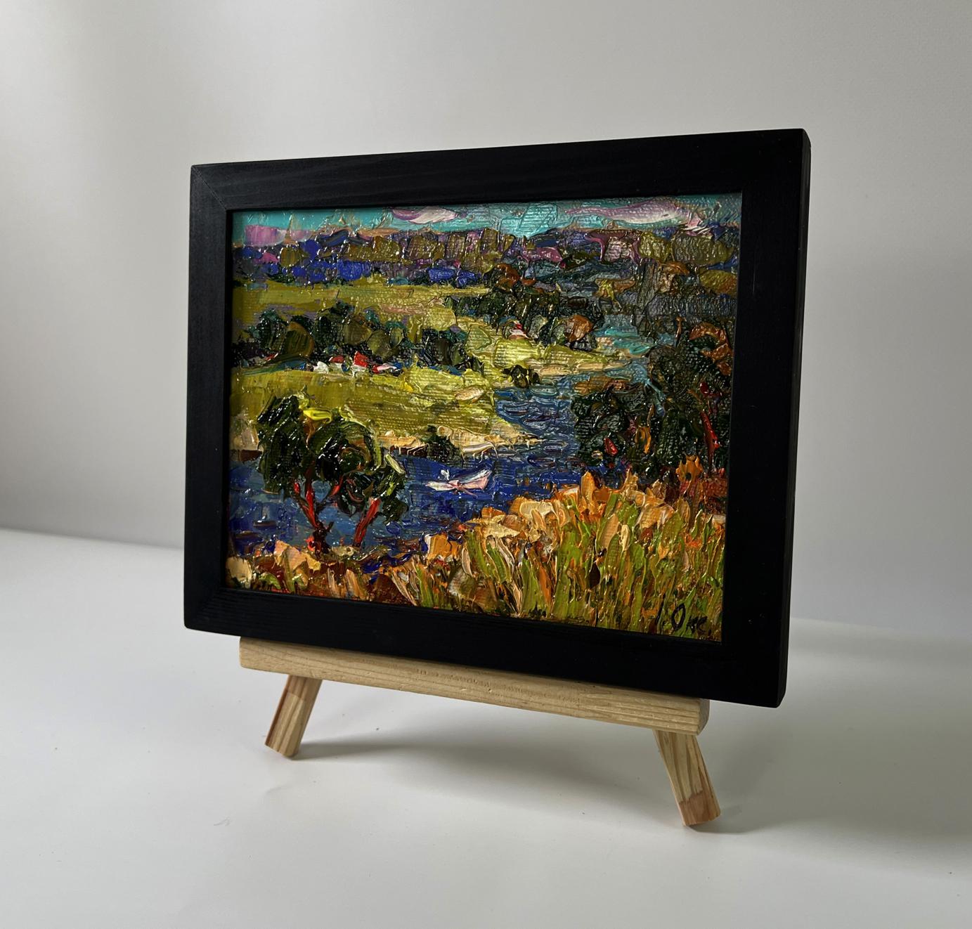 Oil painting Winding village river by Oksana Ivanyuk in black frame on easel