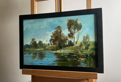 Framed oil painting of serene lake behind village by Yuriy Suprunchuk