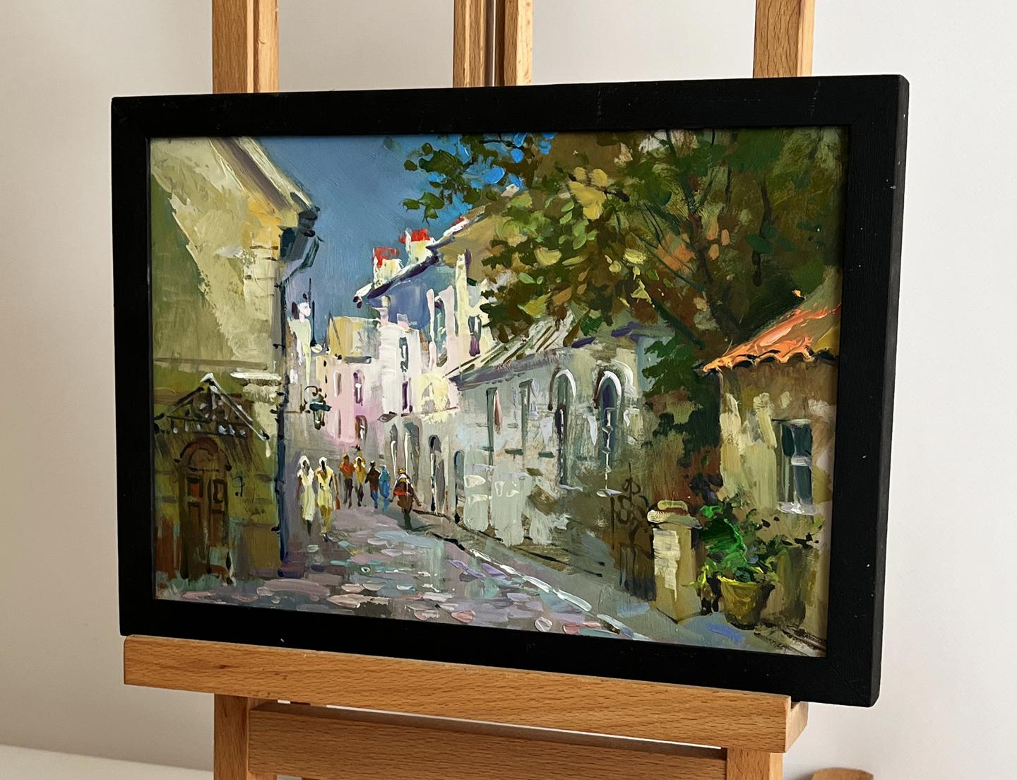 Framed oil painting of sunlit cobblestone street by Yuriy Suprunchuk