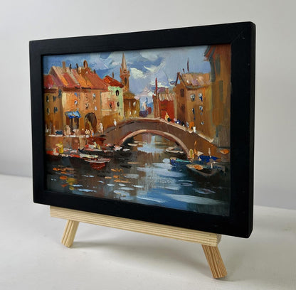 Framed Oil painting City Central Bridge by Yuriy Suprunchuk on easel