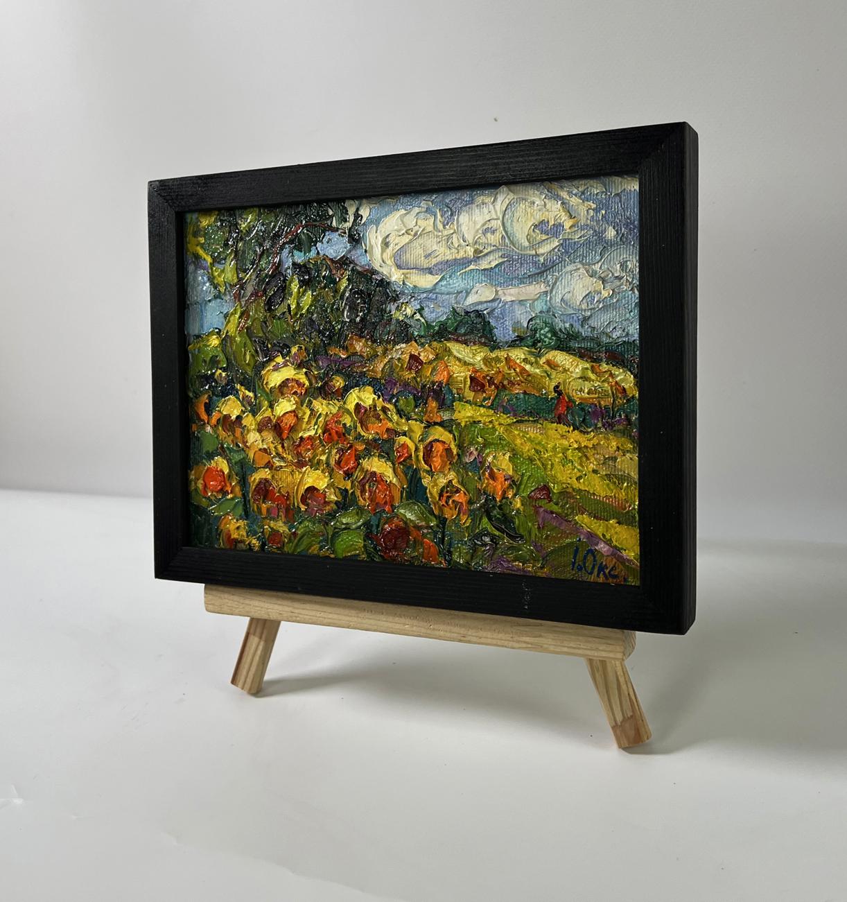 Vibrant oil painting of daytime sunflowers by Oksana Ivanyuk in black frame on easel