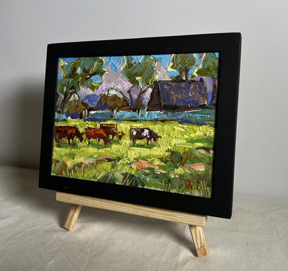 Oil painting Cows on a green field by Oleksiy Ivanyuk on wooden easel