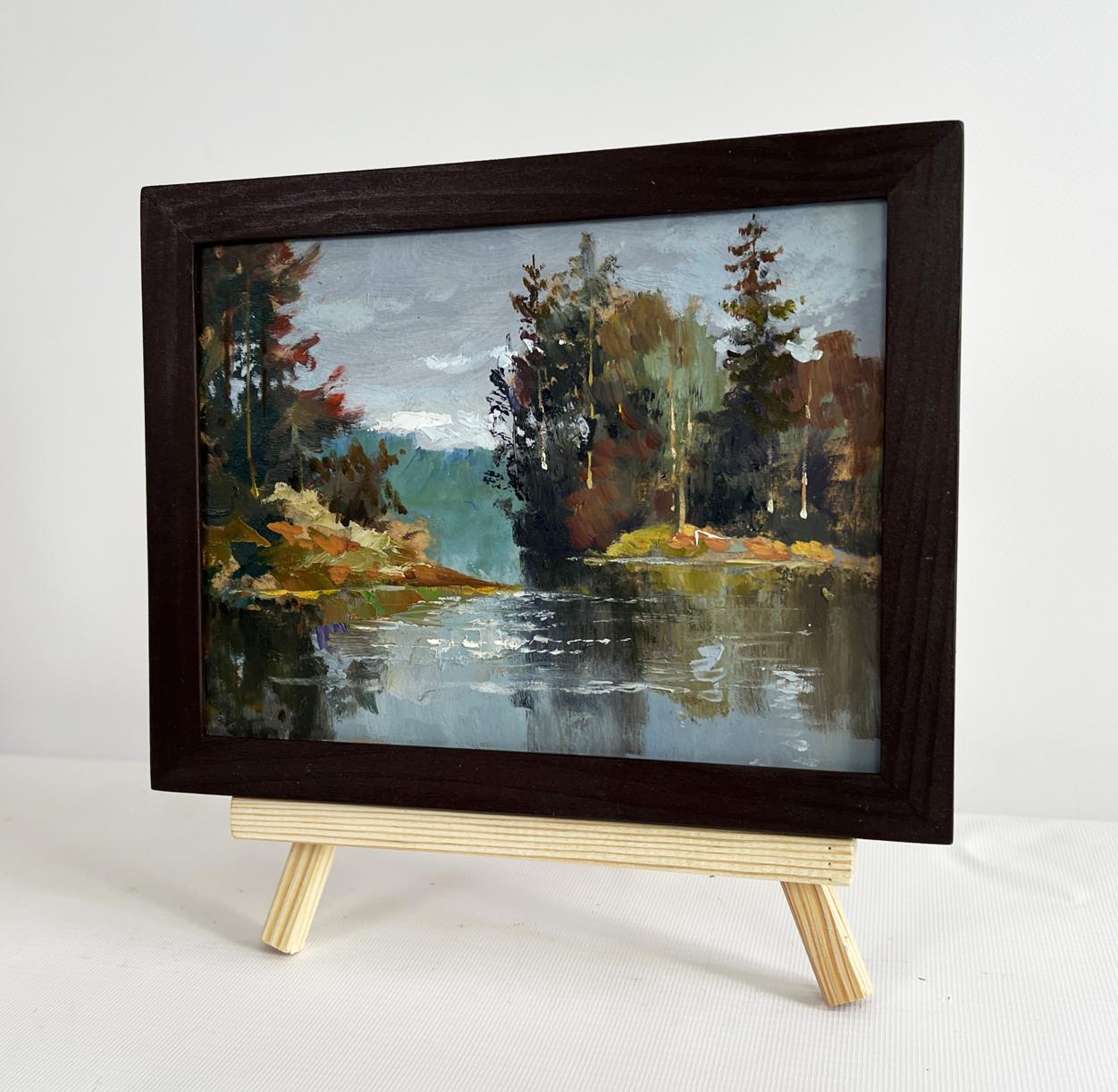 Dark wooden-framed oil painting by Yuriy Suprunchuk of serene autumn forest river scene