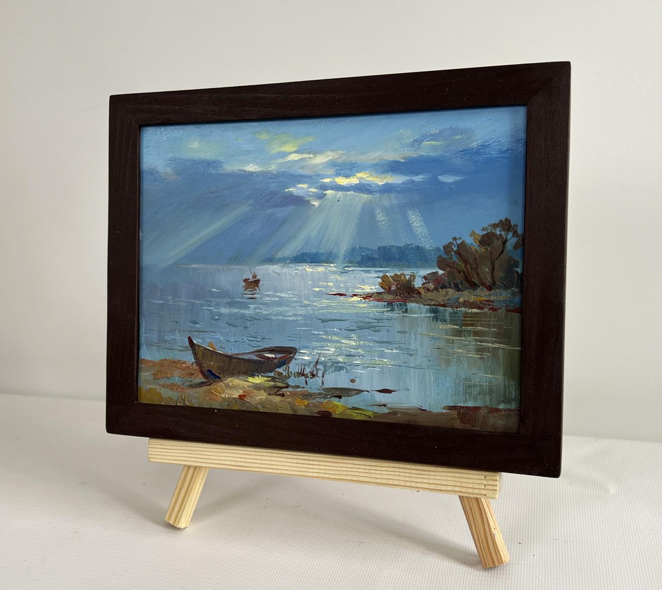 Oil painting Rays of sun through the clouds by Yuriy Suprunchuk in dark frame on easel