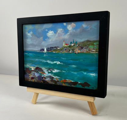 Black-framed miniature oil painting by Yuri Suprunchuk of sailboats at sea and rocky shore