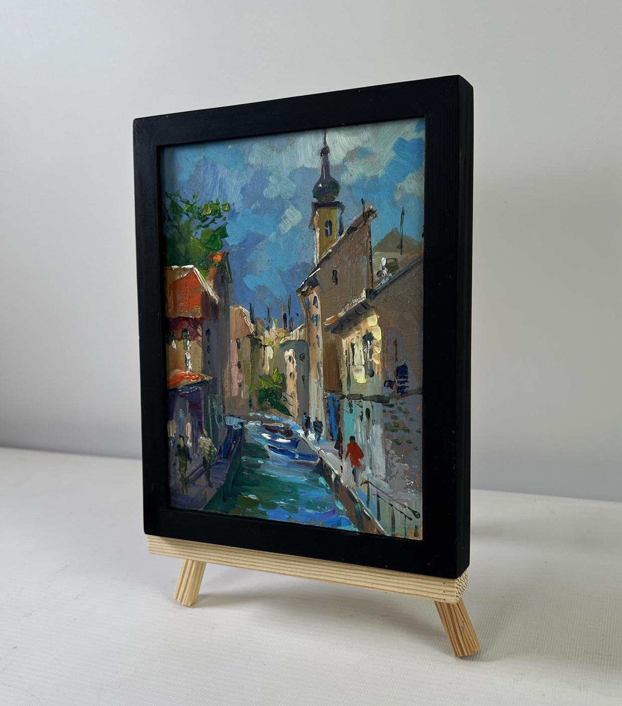 Black-framed miniature oil painting of Yuriy Suprunchuk city street on easel