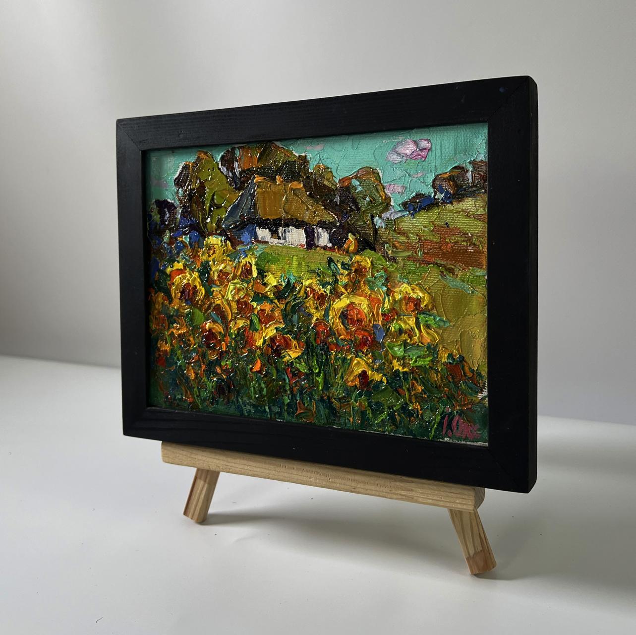 Oil painting of rural sunflowers by Oksana Ivanyuk in black frame on easel