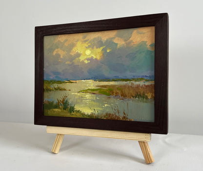 Oil painting The sun says goodbye to the horizon by Yuriy Suprunchuk in dark frame on easel
