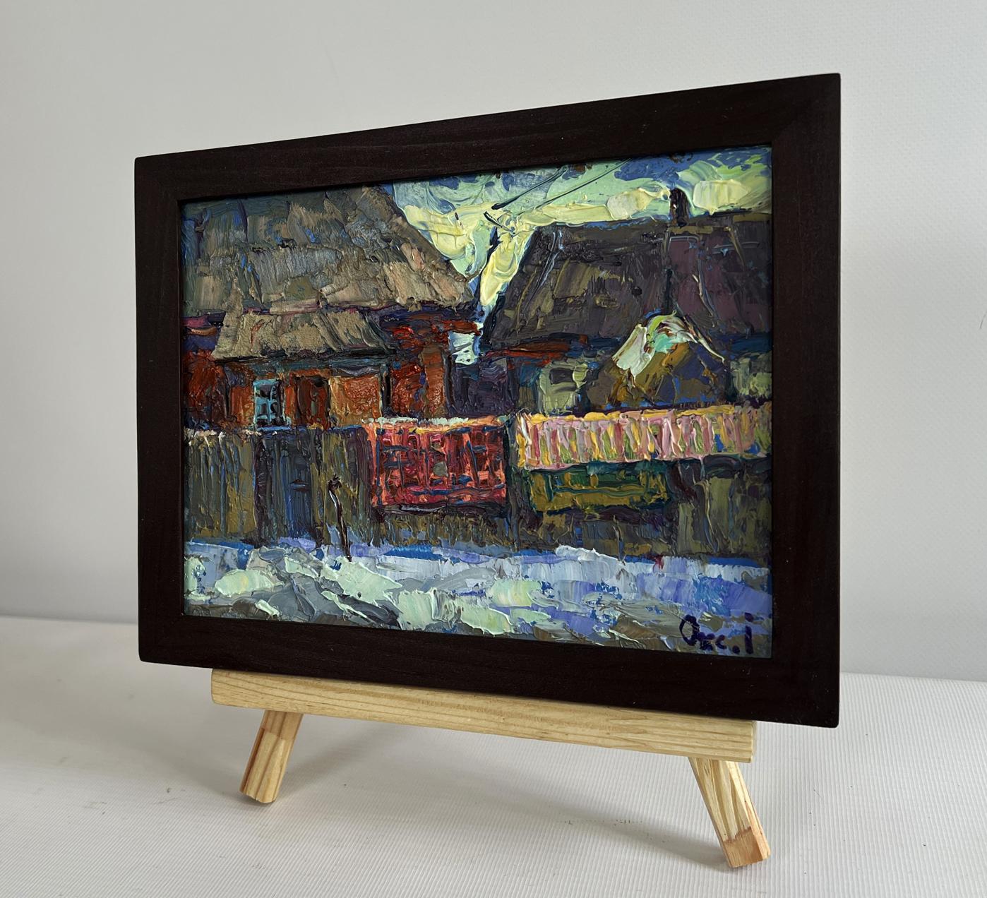 Oil painting by Oksana Ivanyuk: sunset behind village rooftops on easel
