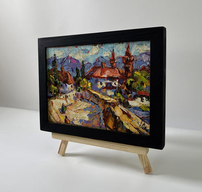 Vibrant oil painting of Oleksiy Ivanyuk old town walking tour in black frame on easel