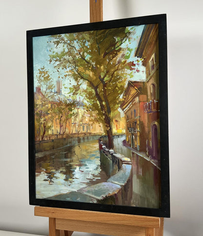 Framed oil painting of sunlit city alley with river by Yuriy Suprunchuk