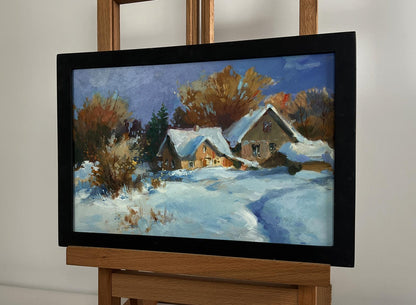 Oil painting by Yuriy Suprunchuk: snow-covered houses in black frame