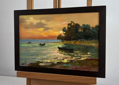 Oil painting of orange sunset over river by Yuriy Suprunchuk in black frame