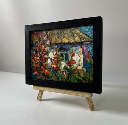 Vibrant oil painting of Oksana Ivanyuk flowers near rustic house in black frame