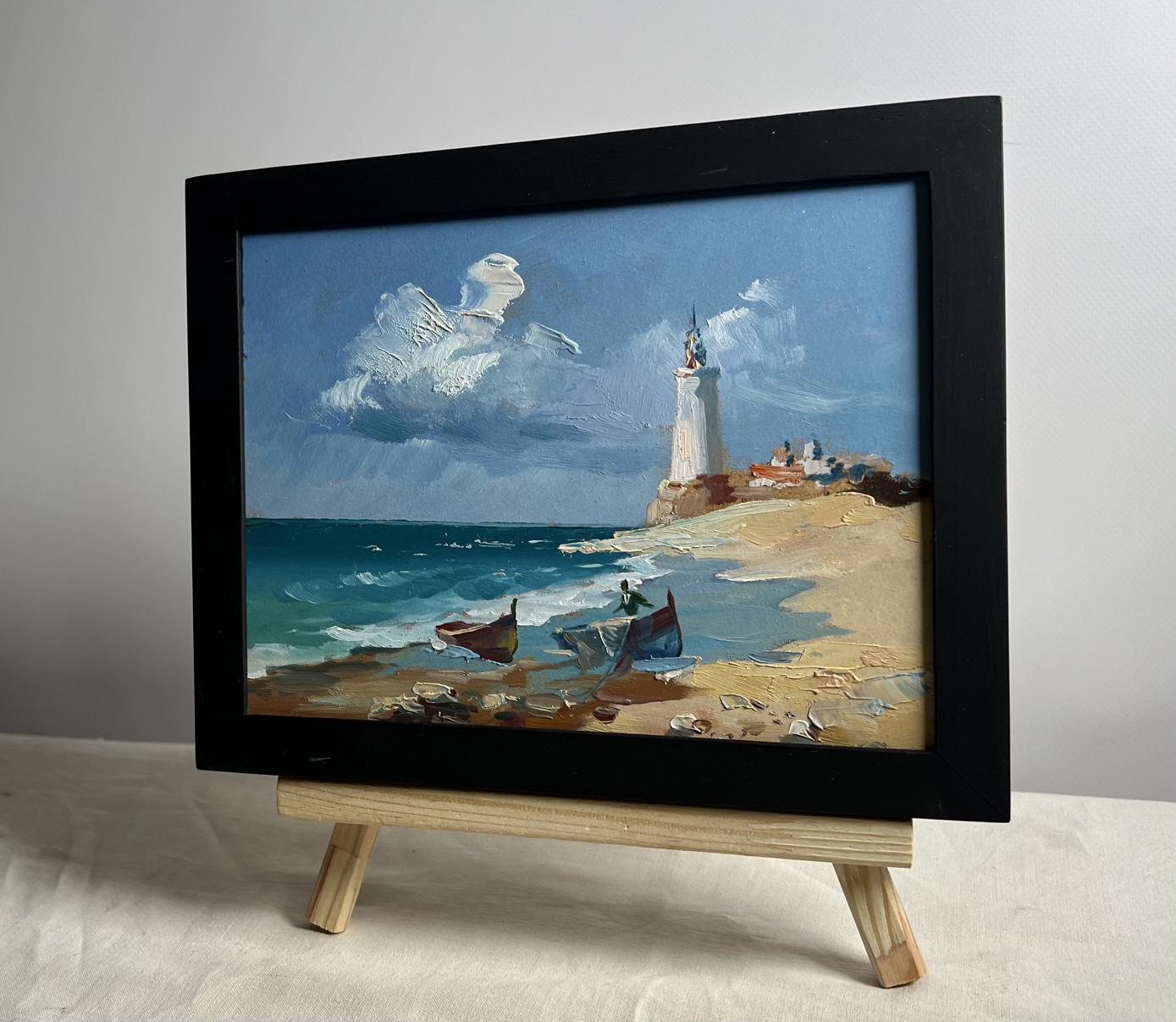 Black-framed oil painting of boats at lighthouse by Yuriy Suprunchuk