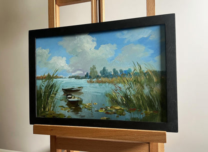 Oil painting by Yuriy Suprunchuk: serene lakeside with boats, reeds, lily pads