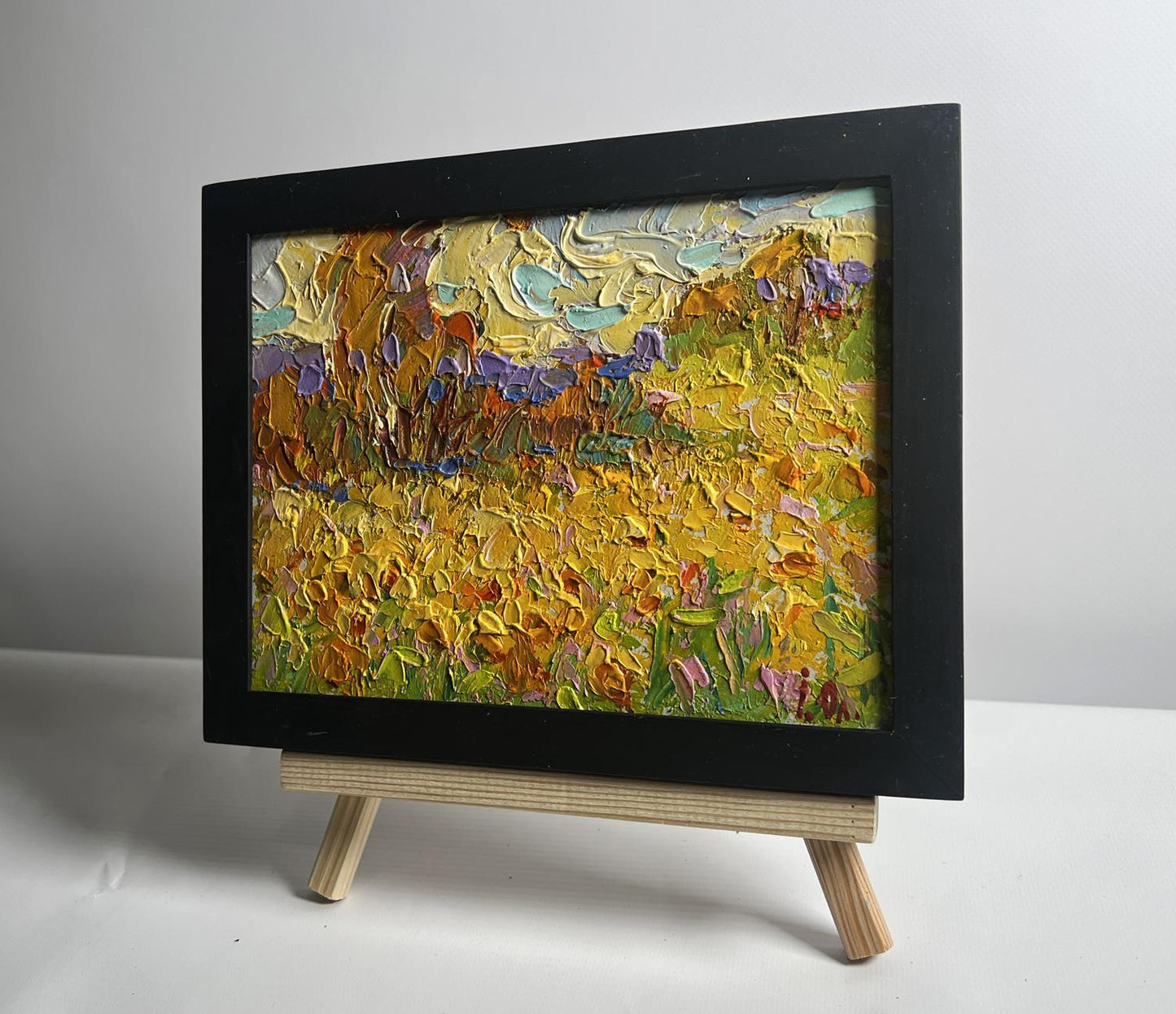 Oil painting of huge sunlit sunflower fields by Oleksiy Ivanyuk in black frame