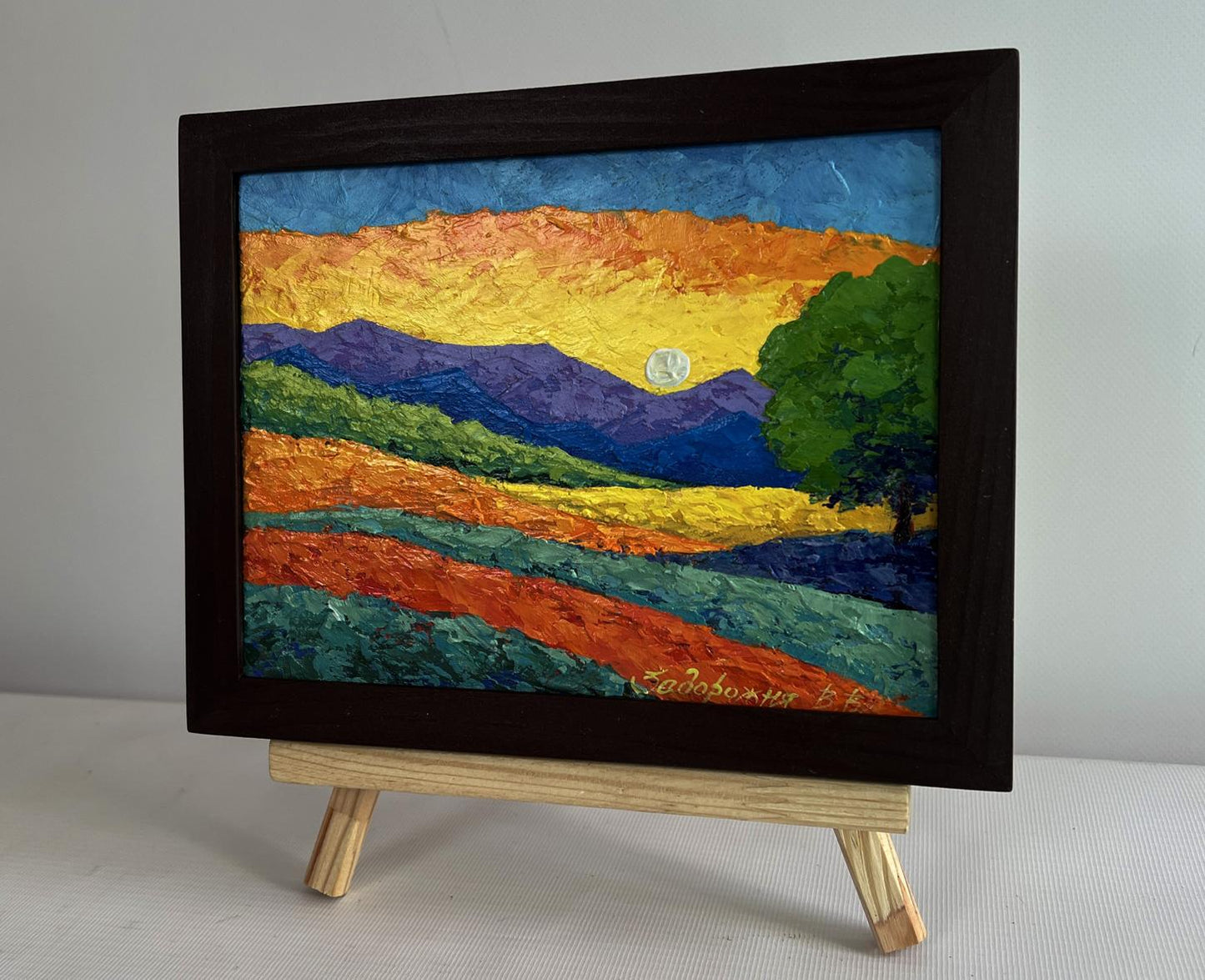 Oil painting of blue mountains with yellow sunset by V. Zadorozhnya in dark frame