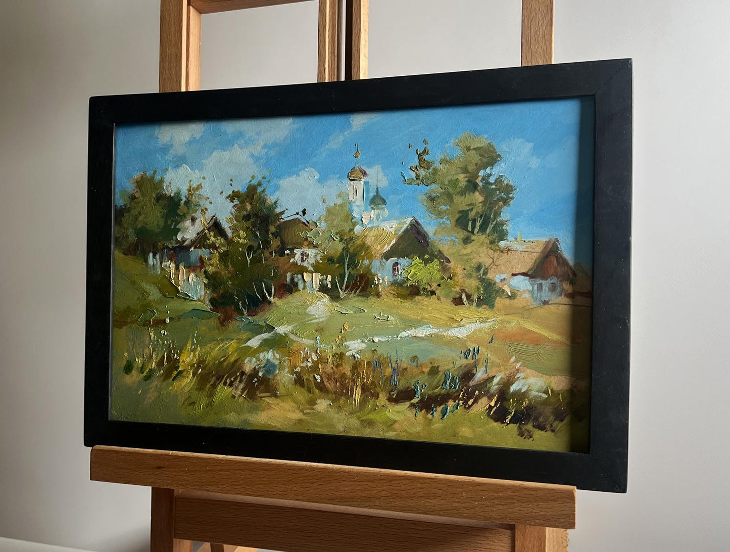 Oil painting of village and church by Yuriy Suprunchuk in frame