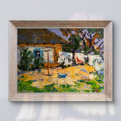 A vibrant impressionist painting in a light wood frame depicts a sunlit rural scene with bold brushstrokes of green, yellow, and blue.