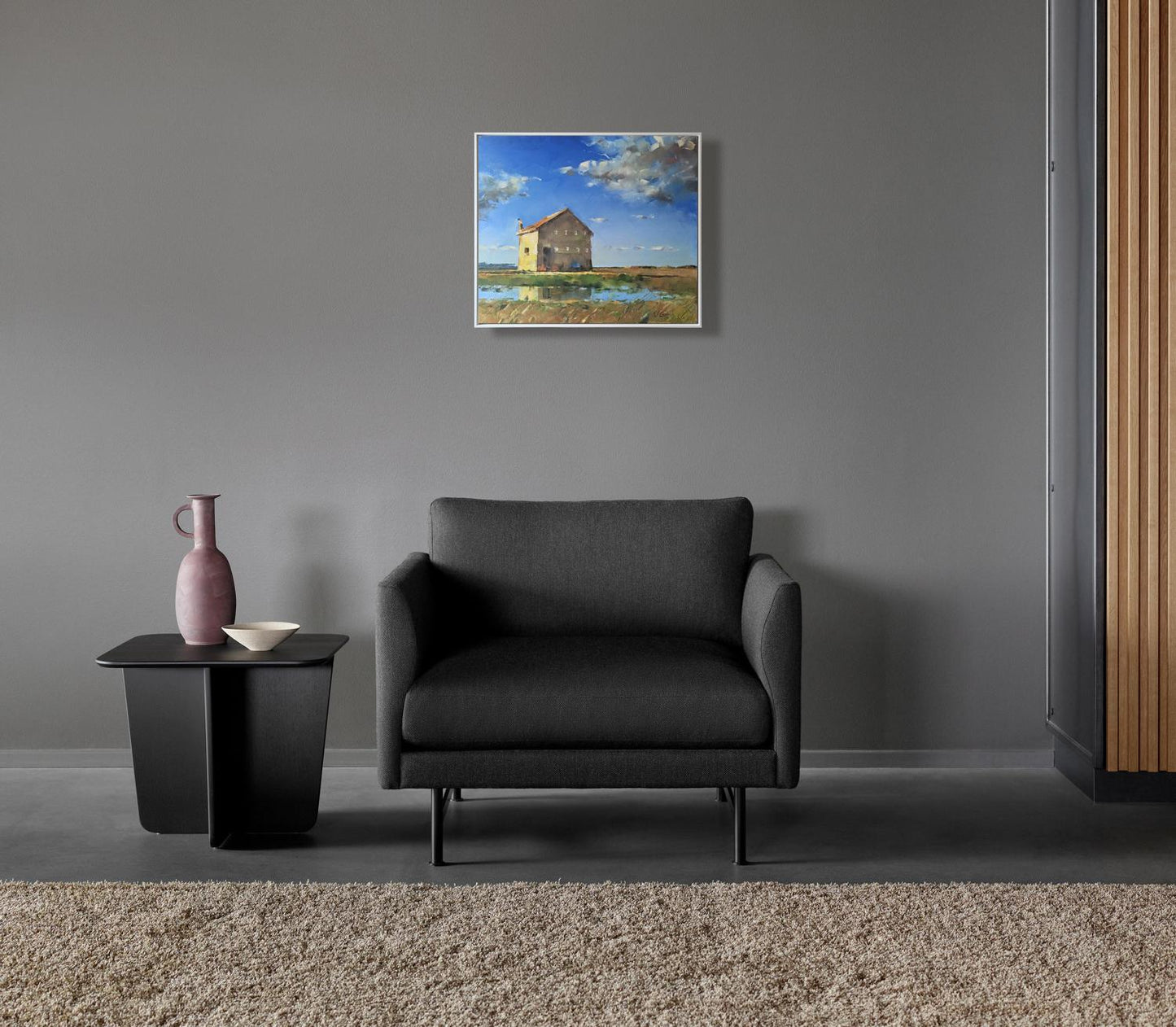 Black upholstered armchair with sleek metal legs by Volodymyr Gluhomanyuk