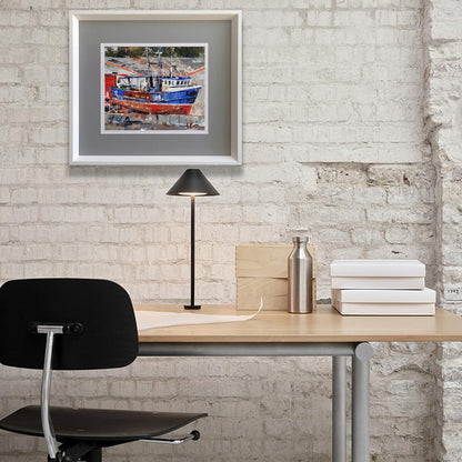 Framed oil painting of red blue boat in city port by Volodymyr Gluhomanyuk on white brick wall