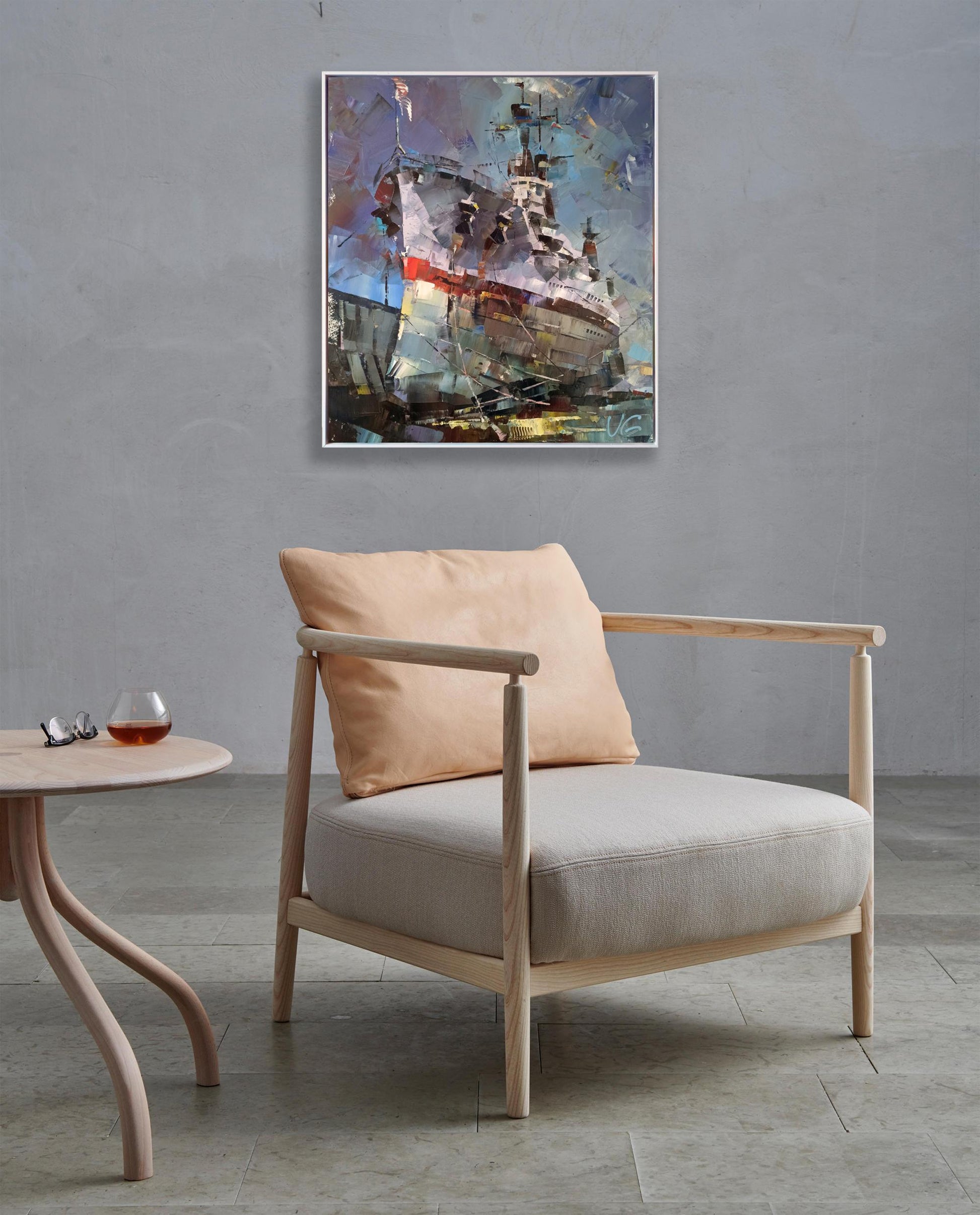 Light wood armchair with beige seat beside USS Texas BB-35 oil painting