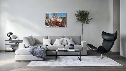Gray sectional sofa with pillows, blanket, oil painting of Cargo ship Turrialba