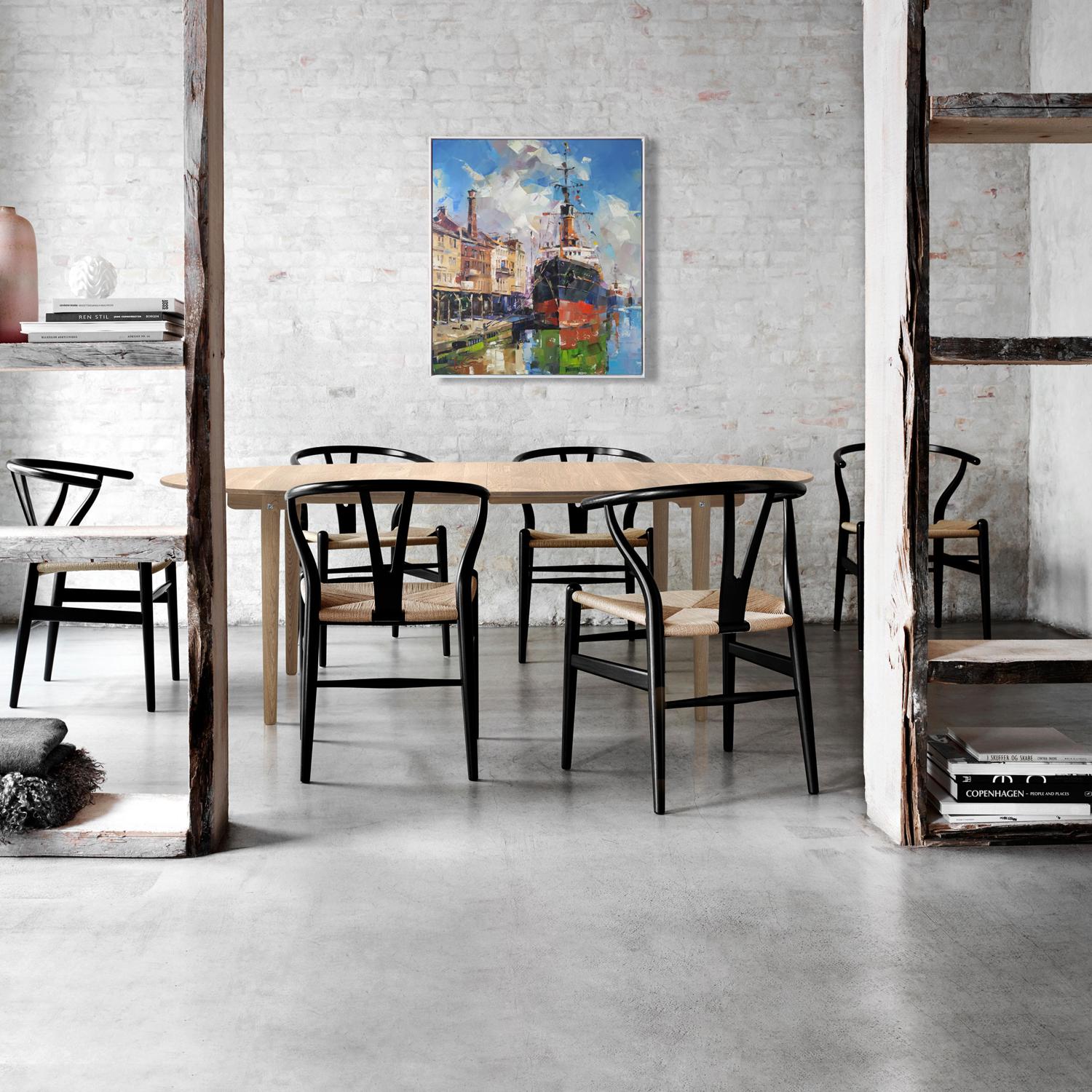 Black and light wood wishbone chairs with woven seats in Oil painting Between two banks Volodymyr Gluhomanyuk