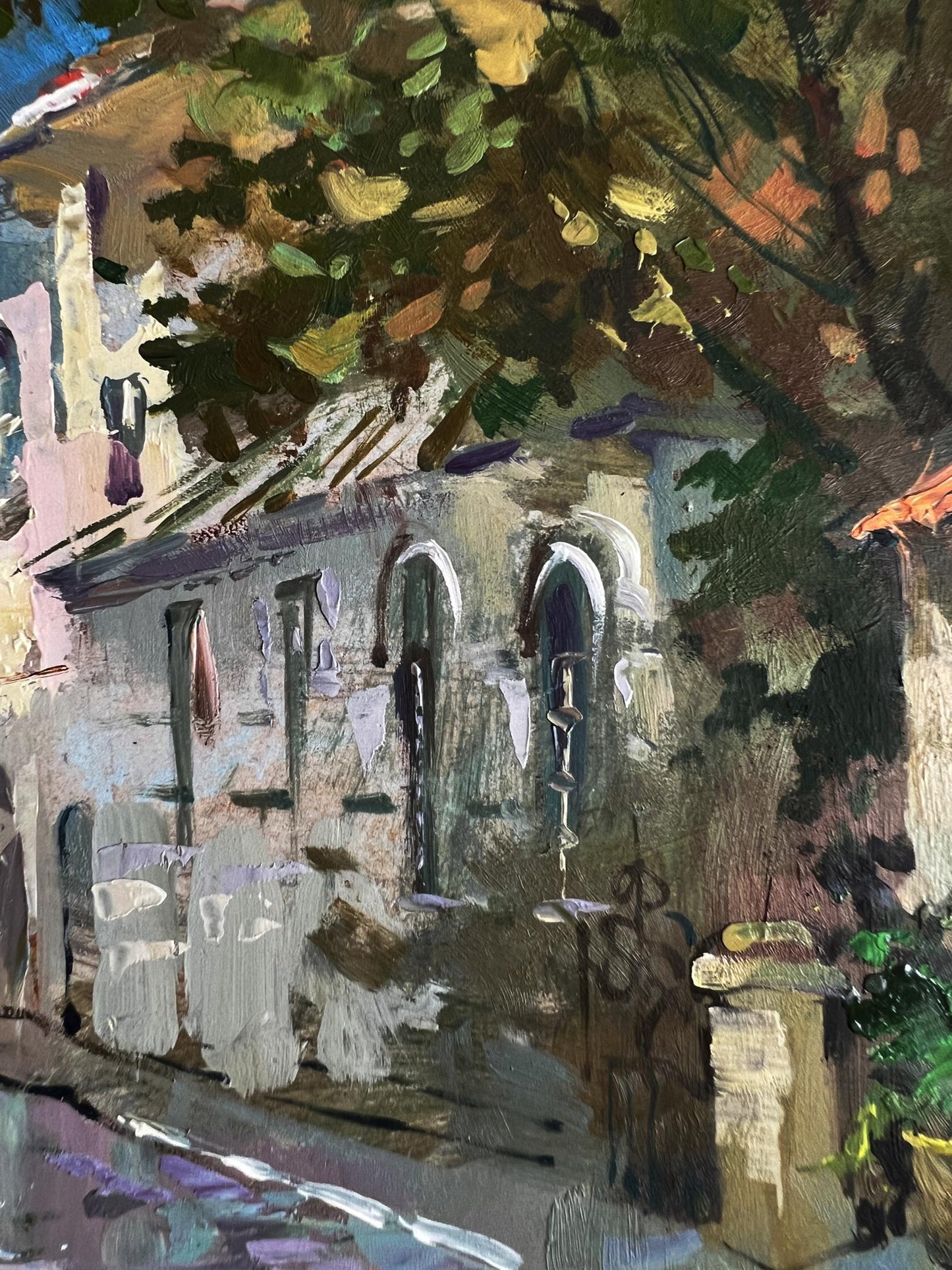 Oil painting by Yuriy Suprunchuk: impressionistic stone building with arched windows, laundry, trees
