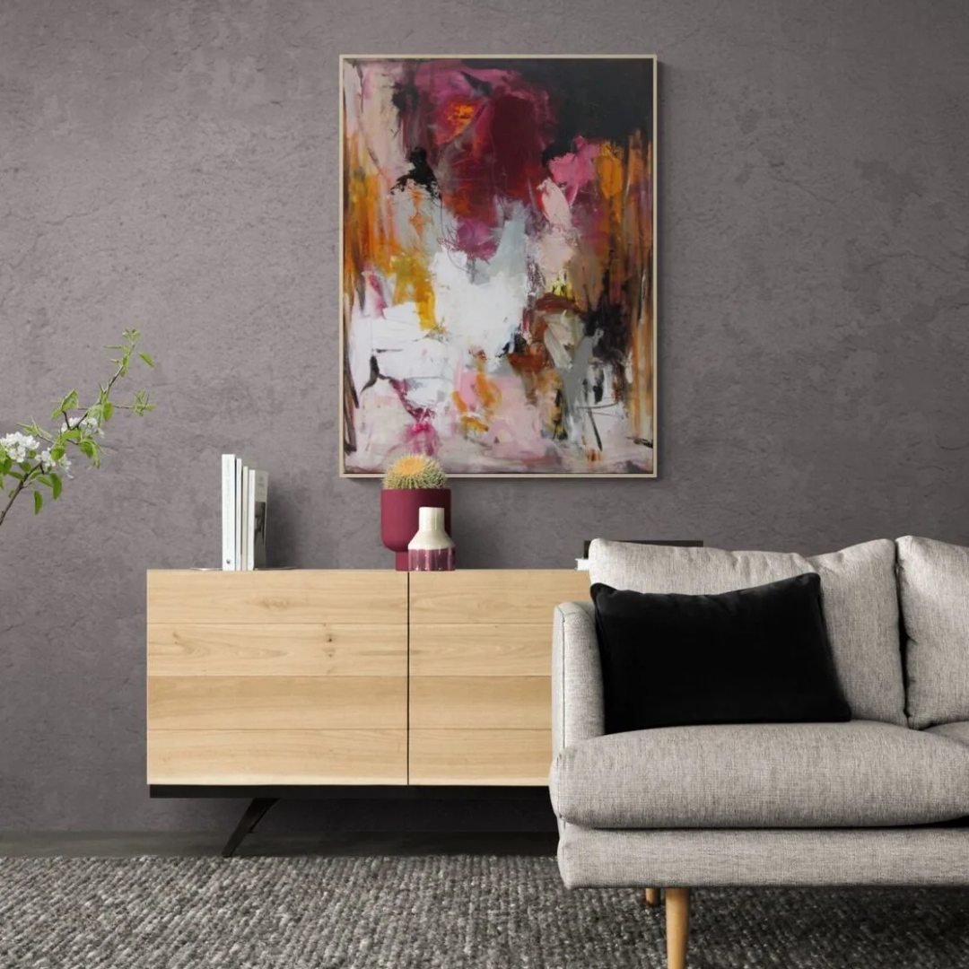Abstract painting with bold strokes of magenta, orange, white, and black on a textured gray wall.