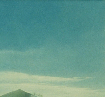 Oil painting by Vasily Korkishko: teal sky, wispy clouds over green hill