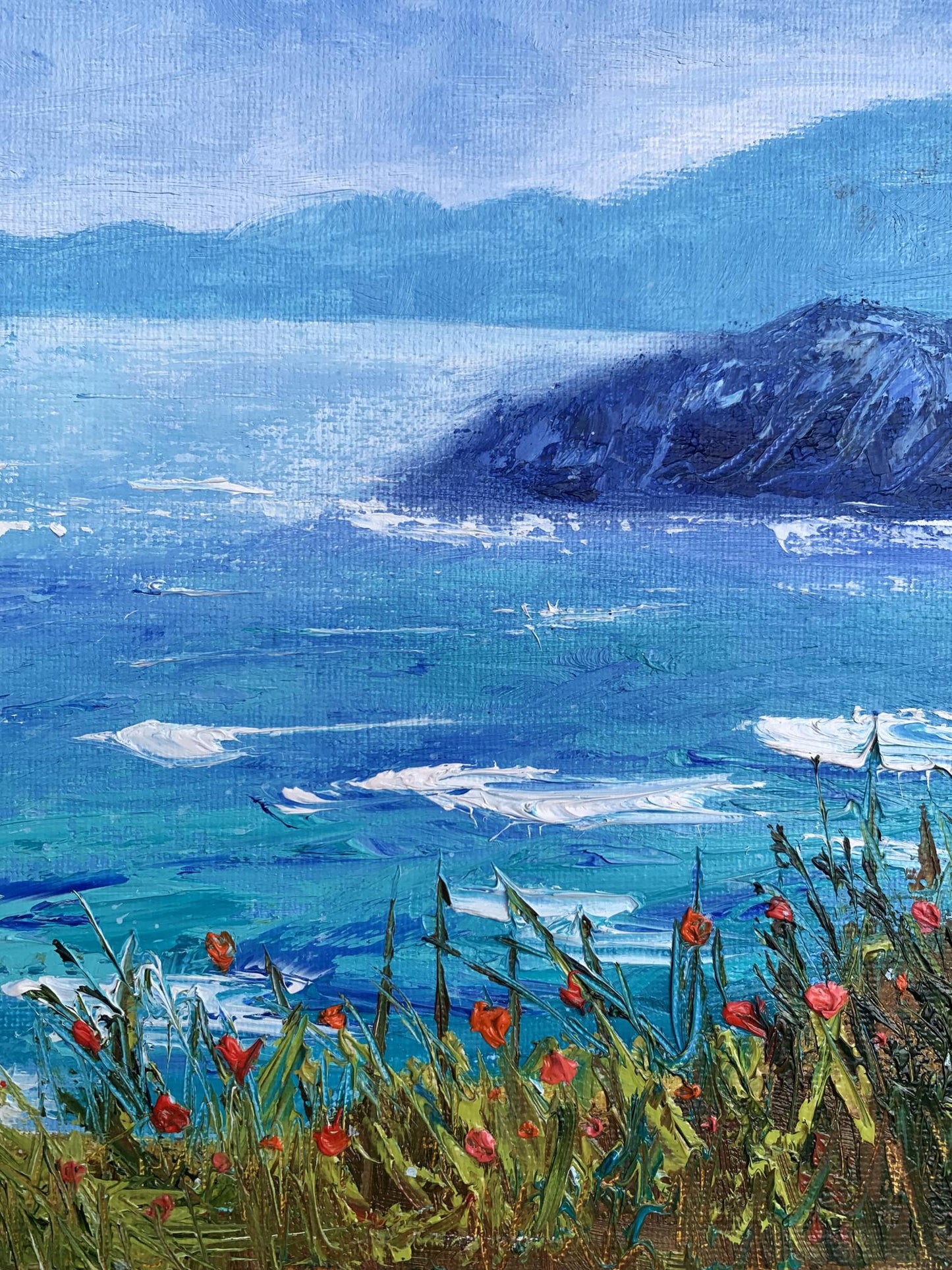 A vibrant impressionist painting of a coastal scene with turquoise waves, distant blue mountains, and red flowers in the foreground.