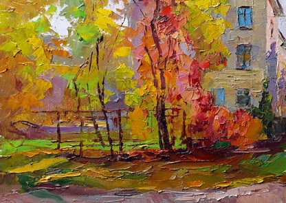 Vibrant impressionist painting of autumn trees with thick, textured brushstrokes in yellows, oranges, and reds against a muted building backdrop.