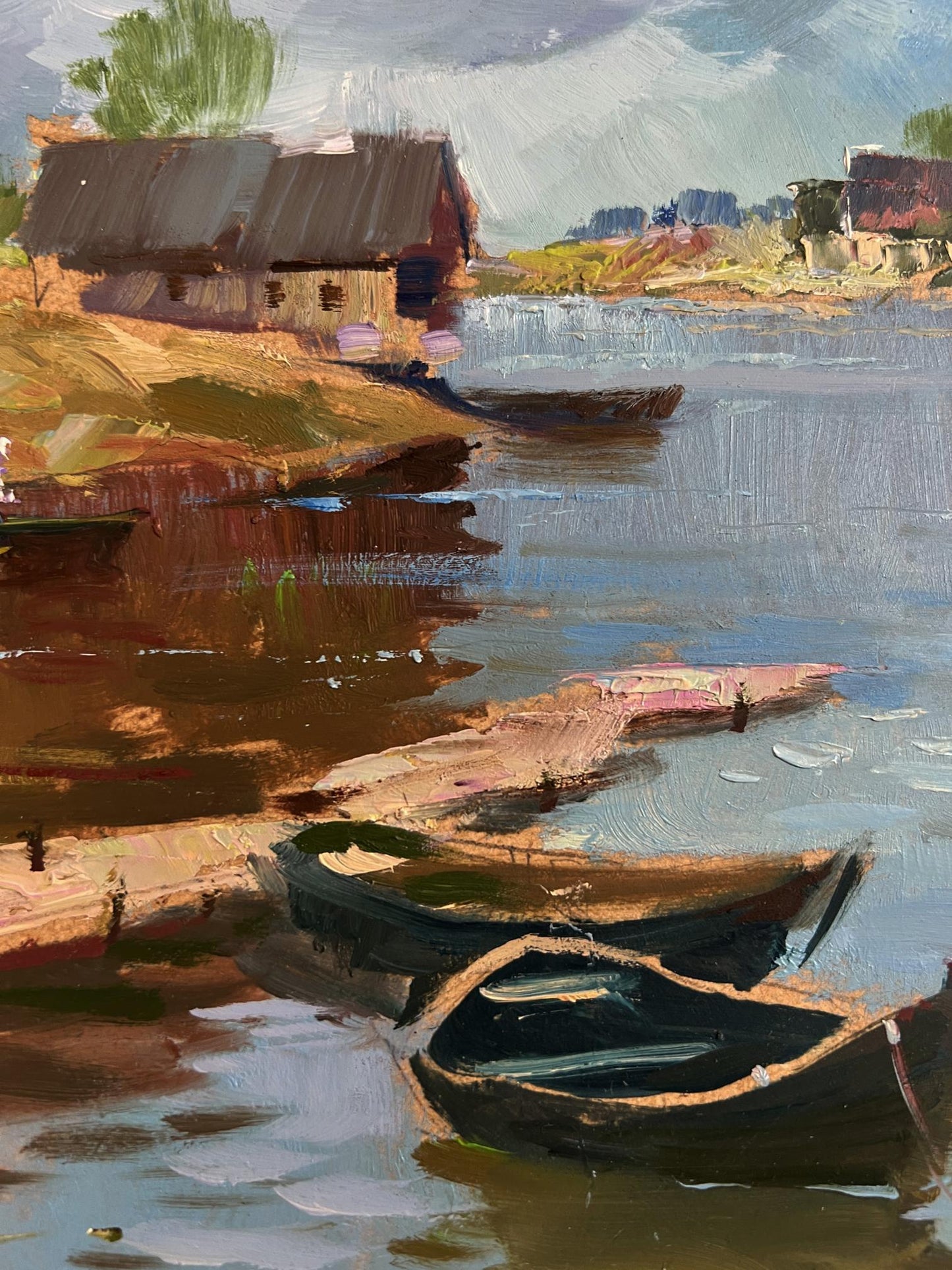 Oil painting of quiet village harbour by Yuriy Suprunchuk: dark rowboats by rustic cottage