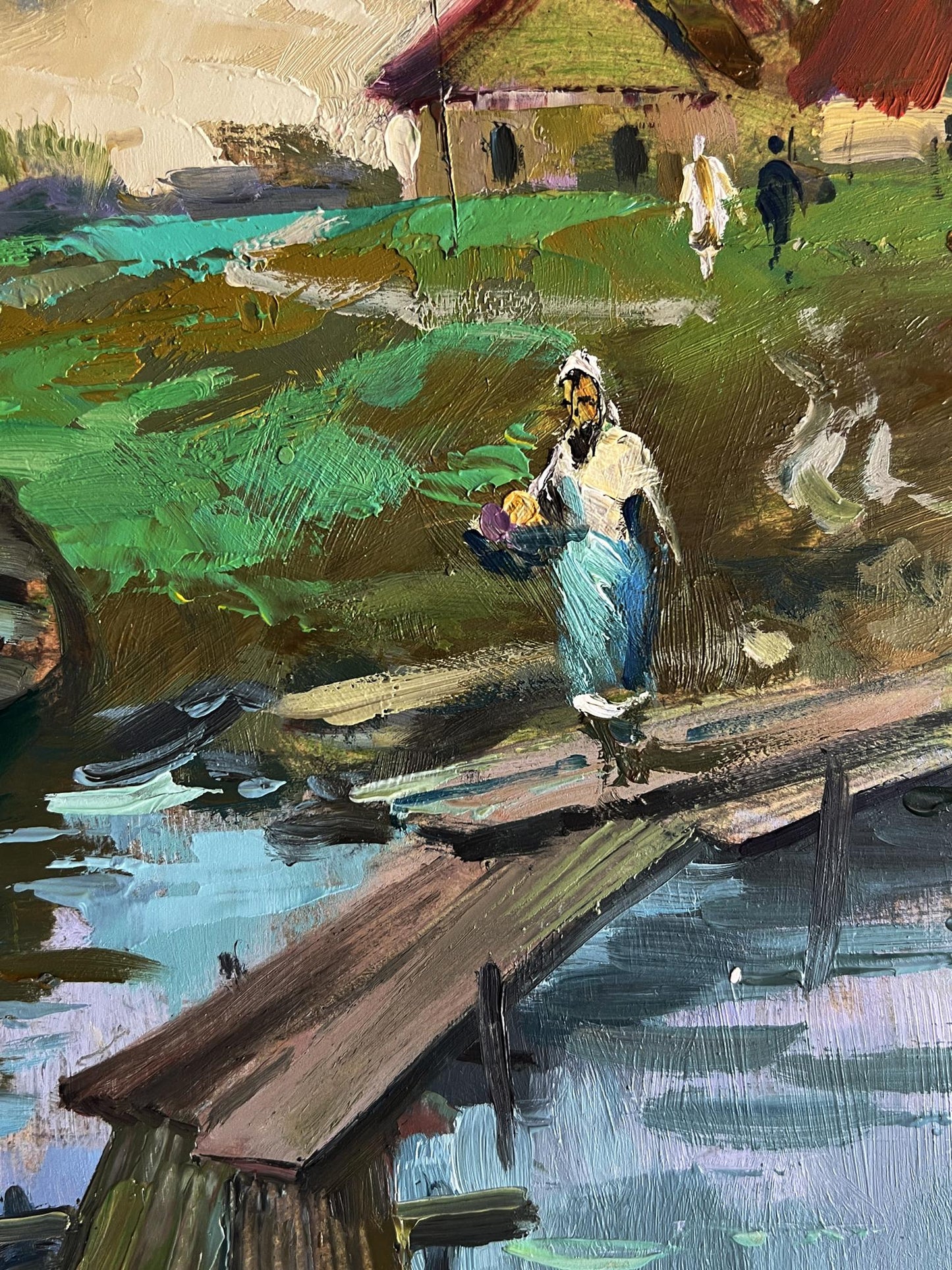 Oil painting by Yuriy Suprunchuk: woman in blue dress crossing village river bridge