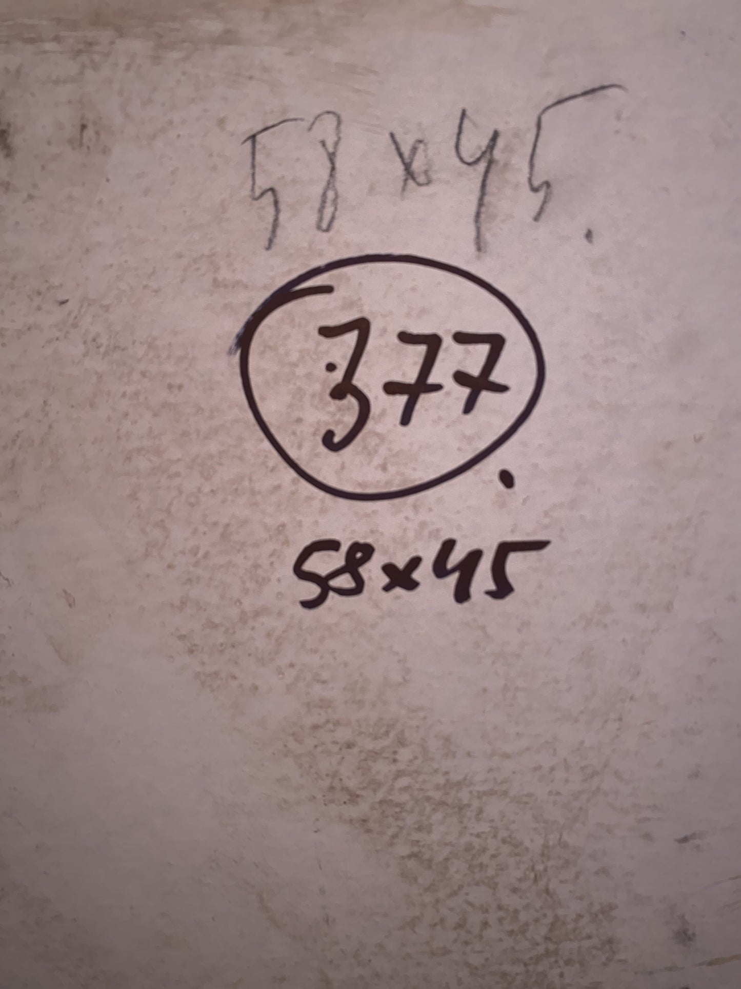 Back of oil painting with sea views showing handwritten measurements and circled 377 on textured surface