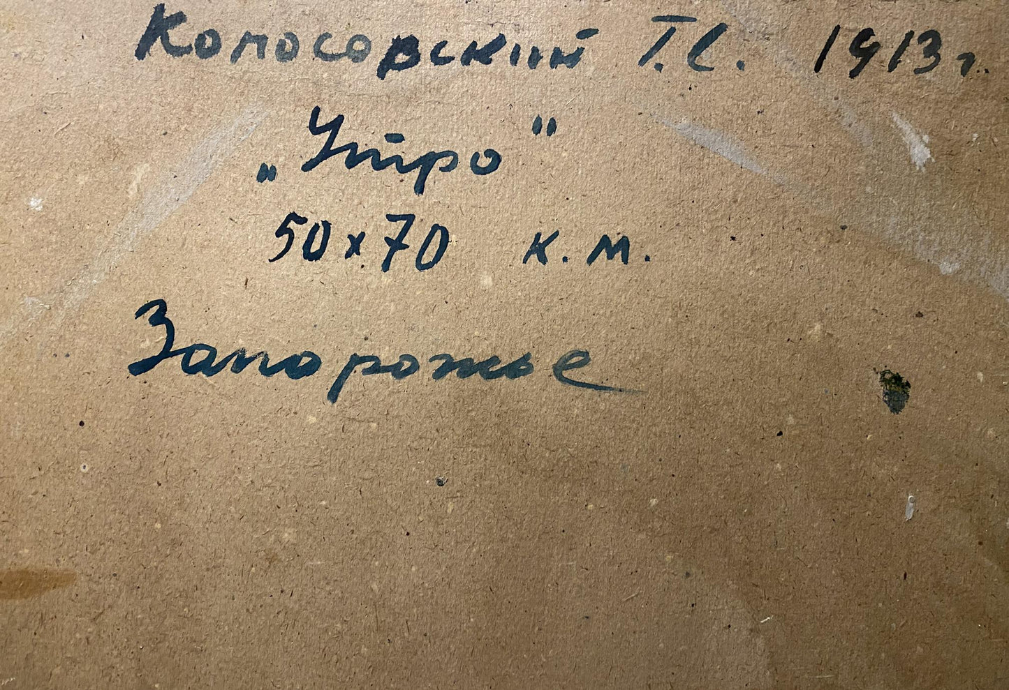 Handwritten inscription in dark ink on a textured brown backing board.