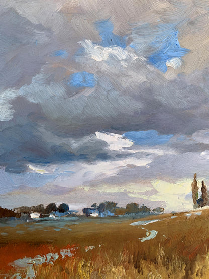 Oil painting Not far from the village by Yuriy Suprunchuk: dramatic sky over golden field