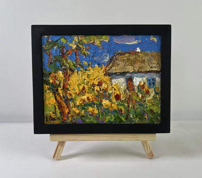 Oil painting of house and sunflowers by Oksana Ivanyuk in black frame