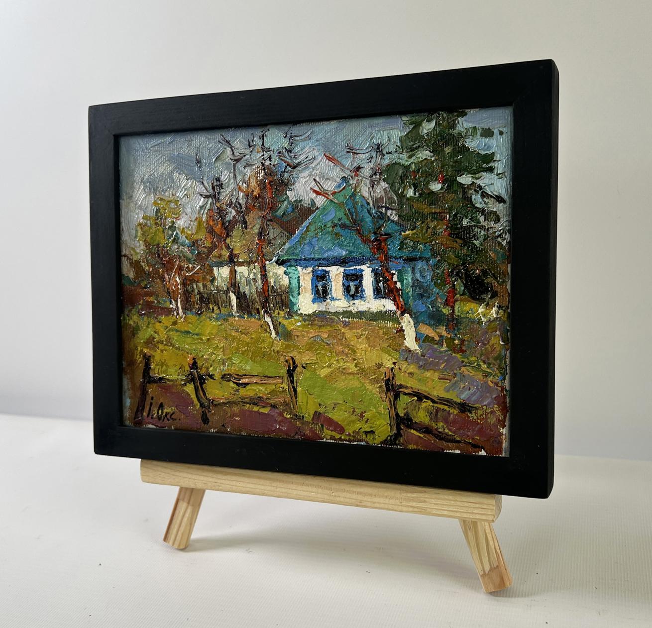 Oil painting Cold March days Oksana Ivanyuk: black-framed miniature blue-roofed house on easel