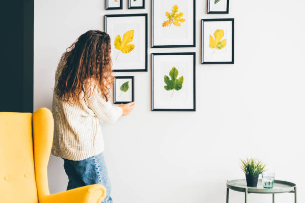 Black-framed wall art featuring pressed yellow and green leaves in white matting.