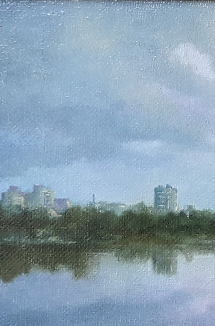 Oil painting by Korkishko Vasily: blue-gray sky, clouds over water reflecting city skyline