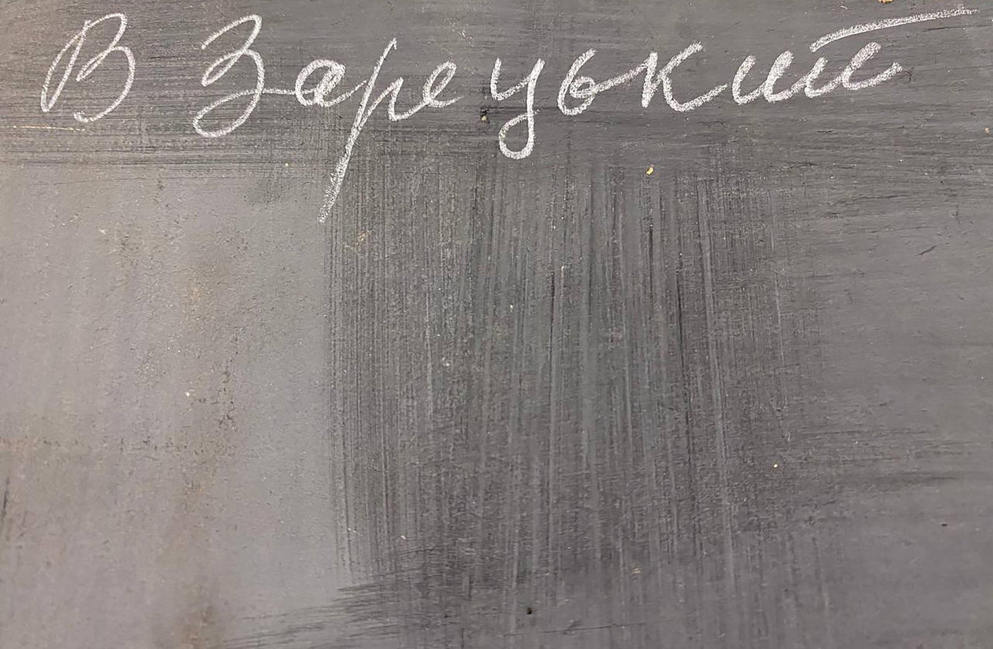 White cursive Oil painting Carpathians Zaretskyi Viktor on dark gray chalkboard