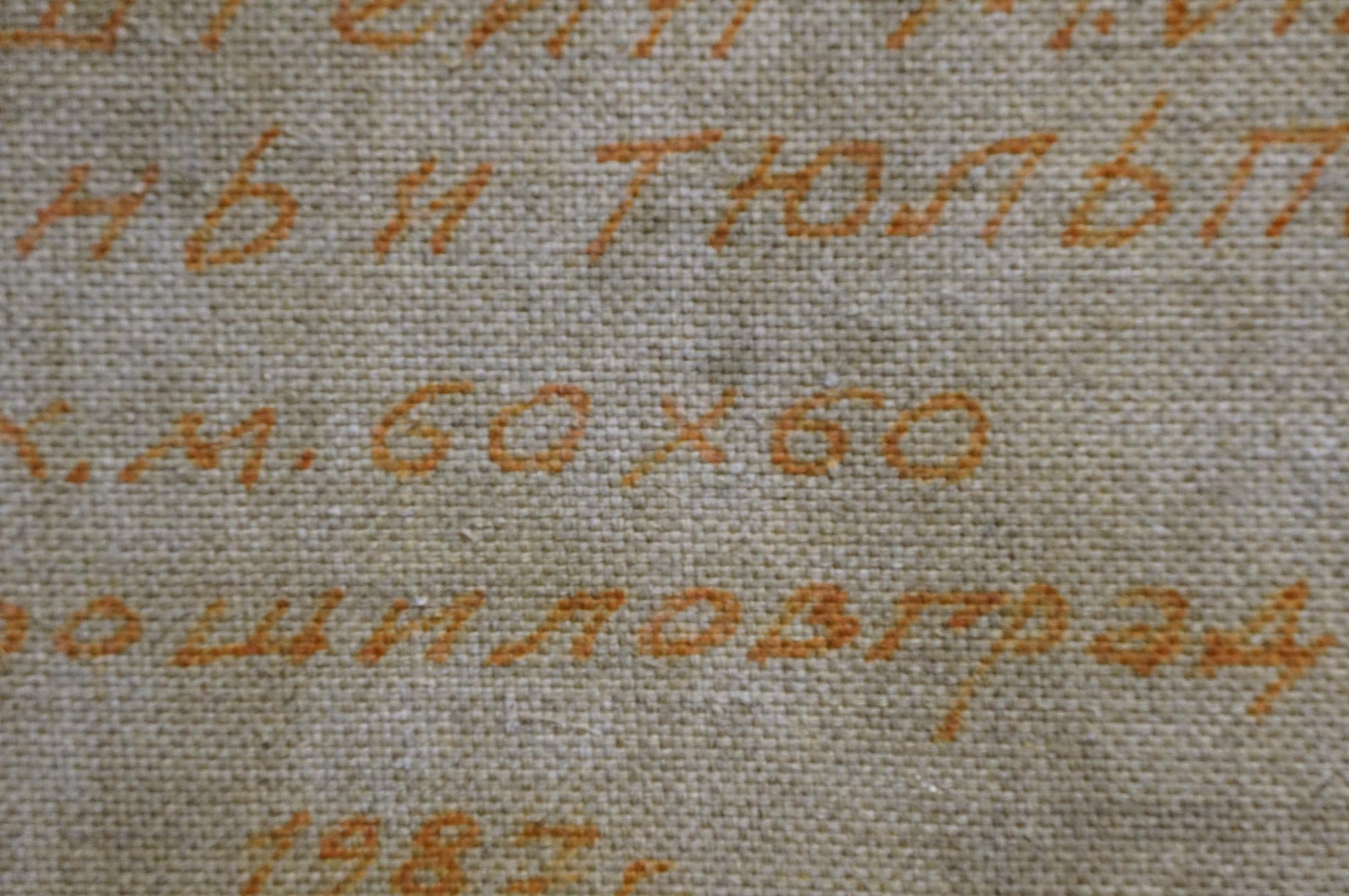 Close-up of embroidered orange Cyrillic script on beige fabric, Lilac by Moisey Lvovich Vol’shteyn